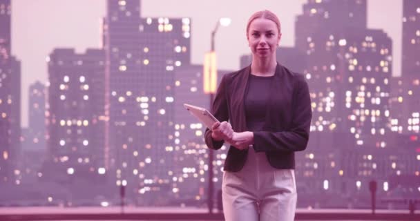 金融分析师或律师使用笔记本电脑 站在街道上与美丽的夜晚纽约市的天际线与摩天大楼 有自信的女商人随便穿正装 高质量的8K镜头 — 图库视频影像