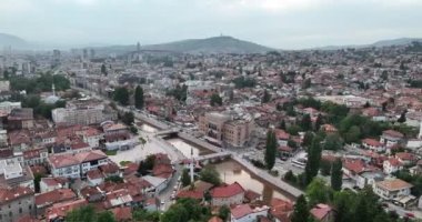 Saraybosna ve ulusal kütüphanenin hava görüntüleri, gün batımında Saraybosna kenti manzaralı Vijecnica kütüphanesinin üzerinde uçuyor. Yüksek kalite 4k görüntü