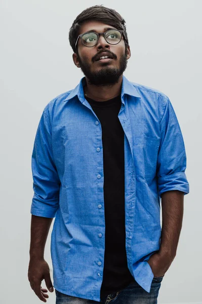身穿蓝色衬衫 戴着灰色背景眼镜 面带微笑的印度年轻人 — 图库照片