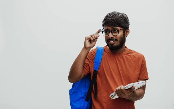 Förvirrad Indisk Student Med Blå Ryggsäck Glasögon Och Anteckningsbok Poserar — Stockfoto