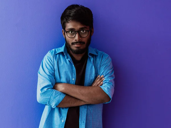 一位身穿蓝色衬衫 戴着眼镜 双臂叉腰 身穿紫色衣服的印度青年学生 — 图库照片