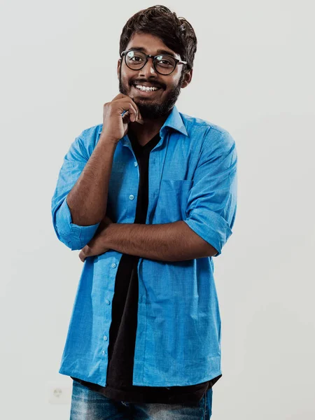 Ung Indisk Man Blå Skjorta Och Glasögon Poserar Eftertänksamt Framför — Stockfoto