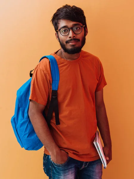 穿着蓝色背包 眼镜和笔记本的印度学生摆出橙色背景 教育和教育的概念 是时候回学校了 — 图库照片
