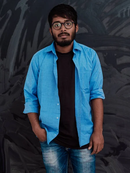 身穿蓝色衬衫 戴着眼镜 面带微笑的印度年轻学生站在学校黑板前 — 图库照片
