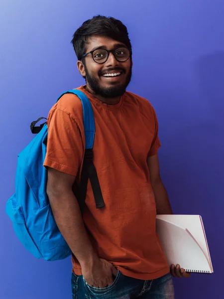 青のバックパック ノートブックを紫色の背景にポーズを持つインドの学生 教育と教育の概念 学校に戻る時間だ — ストック写真