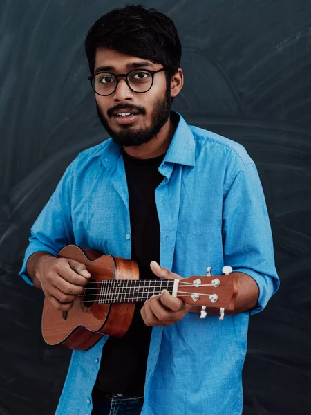 Индийский Юноша Синей Рубашке Очках Играет Гитаре Перед Школьной Доской — стоковое фото