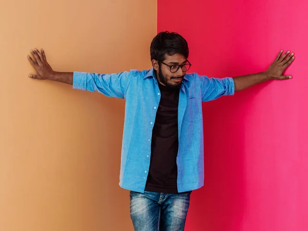 Молодой Индийский Студент Синей Рубашке Очках Позирует Розово Оранжевом Фоне — стоковое фото