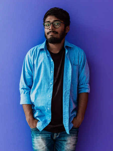 Индийский Улыбающийся Молодой Человек Голубой Рубашке Очках Позирует Фиолетовом Фоне — стоковое фото