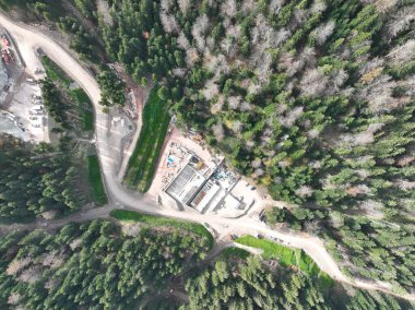 Endüstriyel maden kazıcıları inşaat alanındaki toprağı kazıyor ve kamyonları yüklüyor. Hava aracı üst görüntüsü. Merhaba kaliteli 4K video.