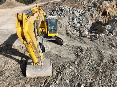 Endüstriyel maden kazıcıları inşaat alanındaki toprağı kazıyor ve kamyonları yüklüyor. Hava aracı üst görüntüsü. Merhaba kaliteli 4K video.