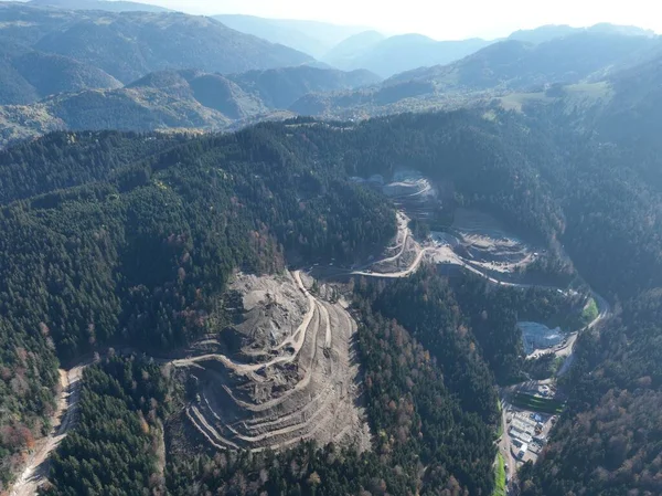 Stock image Industrial mine excavators are digging the soil in the construction site and loading trucks. Aerial drone top view. Hi quality 4K video.