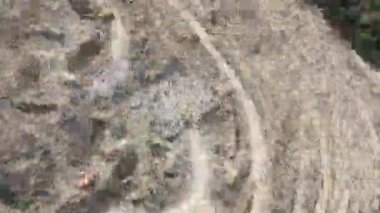 Endüstriyel maden kazıcıları inşaat alanındaki toprağı kazıyor ve kamyonları yüklüyor. Hava aracı üst görüntüsü. Merhaba kaliteli 4K video.