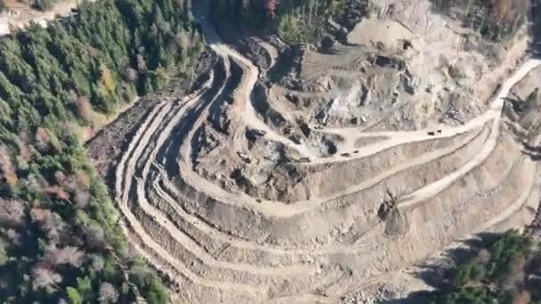 工業用鉱山掘削機は建設現場で土壌を掘り トラックをロードしています 空中ドローンのトップビュー 高品質4Kビデオ — ストック動画
