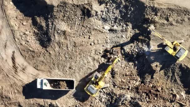 工业矿用挖掘机正在建筑工地挖土和装载卡车 空中无人侦察机俯瞰 高质4K视频 — 图库视频影像