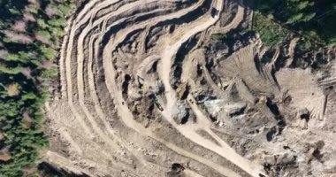 Endüstriyel maden kazıcıları inşaat alanındaki toprağı kazıyor ve kamyonları yüklüyor. Hava aracı üst görüntüsü. Merhaba kaliteli 4K video.