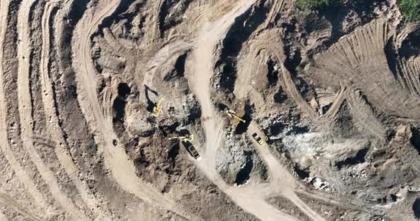 工業用鉱山掘削機は建設現場で土壌を掘り トラックをロードしています 空中ドローンのトップビュー 高品質4Kビデオ — ストック動画