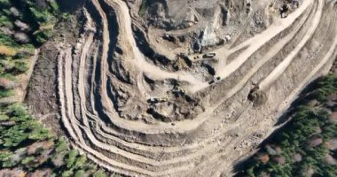 Endüstriyel maden kazıcıları inşaat alanındaki toprağı kazıyor ve kamyonları yüklüyor. Hava aracı üst görüntüsü. Merhaba kaliteli 4K video.