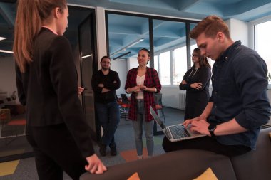 Ofiste yapılan beyin fırtınası sırasında çok kültürlü genç iş adamlarının işbirliği sürecinin en üst görüntüsü. Resmi olarak giyinmiş çeşitli gençler iş birliği yapıyor.