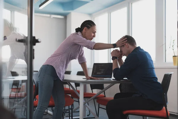 Emotional couple of young colleagues arguing in modern office. African-American business woman shouting at her sad man assistant, copy space, side view.
