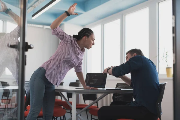 Emotional couple of young colleagues arguing in modern office. African-American business woman shouting at her sad man assistant, copy space, side view.