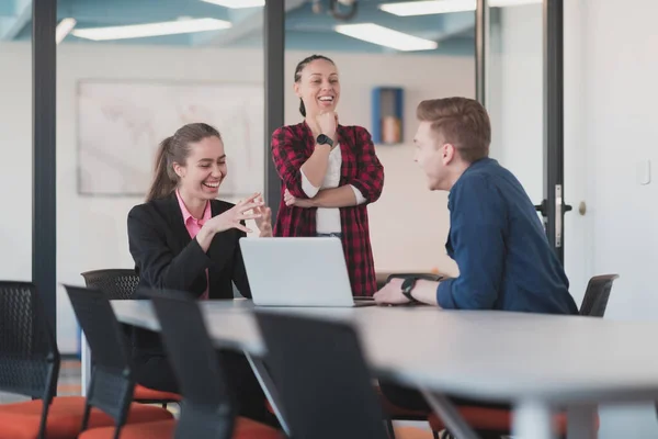 stock image Successful young female leader in a suit with a pink shirt sitting in a modern glass office with a determined smile.Concept of business and the success of young people in modern online businesses 