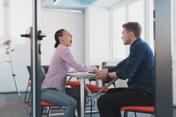 Businesspeople, rivalry and people concept - businesswoman and businessman arm wrestling during corporate meeting in modern bright open space coworking startup business office