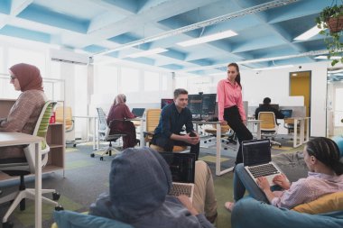 Ofisteki beyin fırtınası sırasında çok kültürlü genç iş adamlarının işbirliği süreci. Resmi giyinmiş çeşitli gençler tasarım geliştirme konusunda işbirliği yapıyorlar.