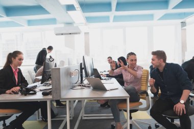 Ofisteki beyin fırtınası sırasında çok kültürlü genç iş adamlarının işbirliği süreci. Resmi giyinmiş çeşitli gençler tasarım geliştirme konusunda işbirliği yapıyorlar.