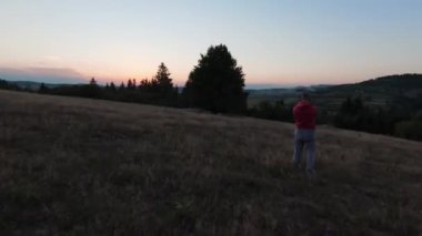 Arka planda güzel bir günbatımı olan güzel çam ağaçları ile tepenin üzerinden hızlı ve manevra yapılabilir bir uçuş. FPV insansız hava aracı ile çekildi. Yüksek kalite 4k görüntü