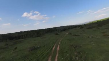 Eski kır yolu üzerinde çam ağaçları ve arka planda güzel günbatımının olduğu dağlarda hızlı ve manevra yapılabilir bir uçuş. FPV insansız hava aracı ile çekildi. Yüksek kalite 4k görüntü