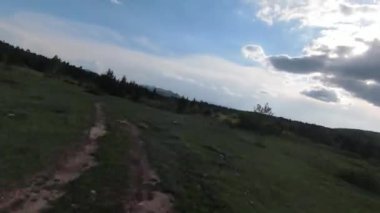 Eski kır yolu üzerinde çam ağaçları ve arka planda güzel günbatımının olduğu dağlarda hızlı ve manevra yapılabilir bir uçuş. FPV insansız hava aracı ile çekildi. Yüksek kalite 4k görüntü