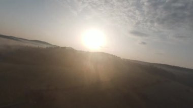 Arka planda güzel bir günbatımı olan orman ve ağaç tepeleriyle tepenin üzerinden hızlı ve manevra yapılabilir bir uçuş. FPV insansız hava aracı ile çekildi. Yüksek kalite 4k görüntü