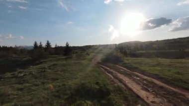 Eski kır yolu üzerinde çam ağaçları ve arka planda güzel günbatımının olduğu dağlarda hızlı ve manevra yapılabilir bir uçuş. FPV insansız hava aracı ile çekildi. Yüksek kalite 4k görüntü
