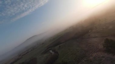 Arka planda güzel bir günbatımı olan orman ve ağaç tepeleriyle tepenin üzerinden hızlı ve manevra yapılabilir bir uçuş. FPV insansız hava aracı ile çekildi. Yüksek kalite 4k görüntü