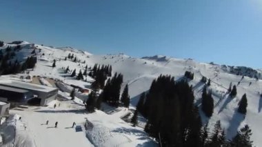 Karlı kışta dağ ve bulutlu bir günde yamaçta kayak yapan insanlar. FPV İHA Jahorina, Bosna-Hersek Olimpiyat Dağı. Yüksek kalite 4K görüntü