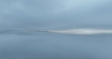 Dağlarda yağışlı hava. Çam ağacı ormanında sisli bir sis esiyor. Sisli bir günde dağ tepelerindeki ladin ormanlarının hava görüntüleri. Soyut kopyalama alanı doğal arkaplan. Merhaba kalite 4K