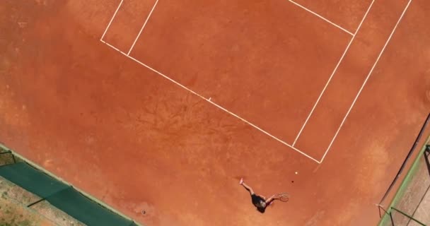 茶色いコートで遊ぶ若い女性テニス選手の空中トップビュー コートで背部を打つプロの女の子テニス選手フラットレイアウトスポーツの背景 高品質の写真 — ストック動画