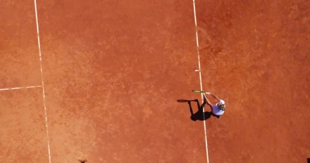 空中俯瞰一位年轻女子网球选手在棕色场地上的比赛 职业女子网球选手在球场上反手击球平面布局的运动背景 高质量的照片 — 图库视频影像