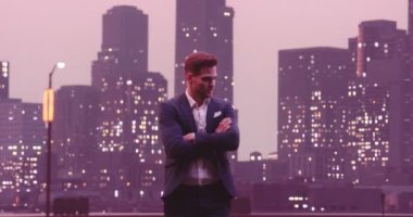 Yakışıklı iş adamı pozu gülümse ve bak kamera gecesi New York Skyline City ofis binaları arka planda. Yüksek kalite 8K görüntü