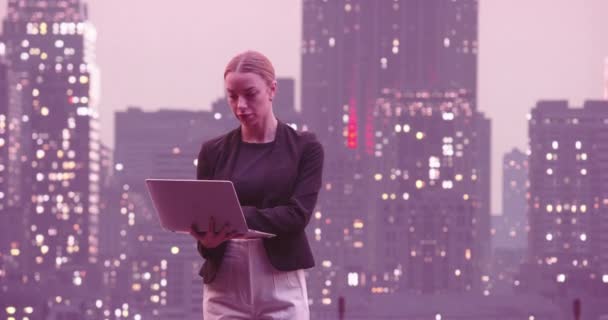 金融アナリストや弁護士ノートパソコンを使用して 美しい夜ニューヨーク市スカイラインと街に立って高層ビル 自信のあるビジネス女性カジュアルなフォーマルウェア 高画質8K映像 — ストック動画