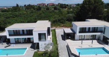 Birbirine tıpatıp benzeyen iki tatil evi ya da deniz manzaralı villaların insansız hava aracı görüntüleri. Yüksek kalite 4k görüntü