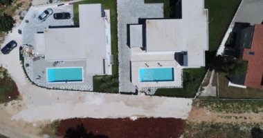 Birbirine tıpatıp benzeyen iki tatil evi ya da deniz manzaralı villaların insansız hava aracı görüntüleri. Yüksek kalite 4k görüntü