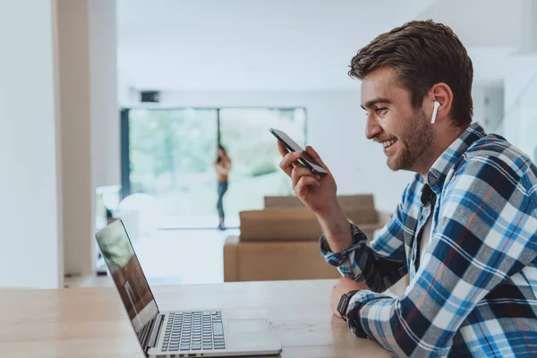 Muž Sedí Stolu Moderním Obývacím Pokoji Používá Smartphone Notebook Pro — Stock fotografie