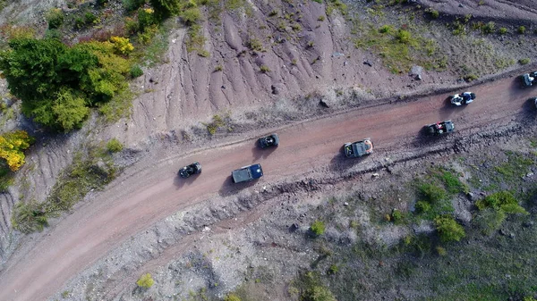 Aerial drone view of ATV quads on a dirt trail in forests. Off-road group team club enthusiasts having fun while driving countryside roads. High quality 4k footage