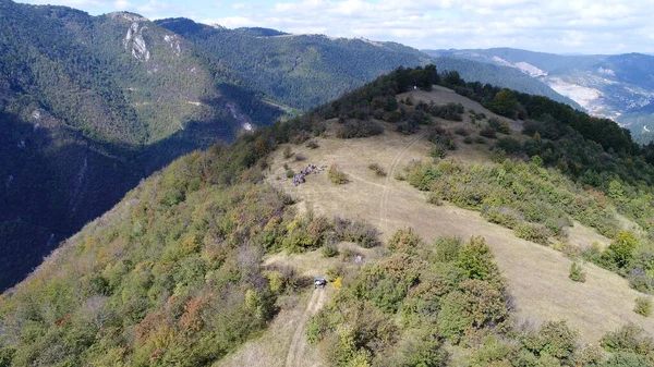 Aerial drone view of ATV quads on a dirt trail in forests. Off-road group team club enthusiasts having fun while driving countryside roads. High quality 4k footage
