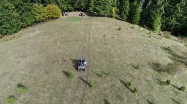 Ormanlardaki toprak bir patikada ATV kuadlarının hava aracı görüntüsü. Off-road grubu kulüp meraklıları kırsal yollarda araba sürerken eğleniyorlar. Yüksek kalite 4k görüntü