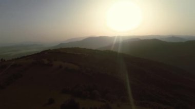 Sonsuz bir dağ ve orman manzarasının sinematik görüntüsü. Gün batımında Dağ 'daki tepelerin üzerinden uçacağız. Merhaba kaliteli 4K görüntüler.