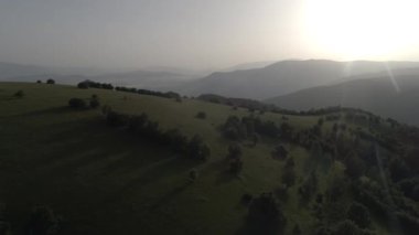 Sonsuz bir dağ ve orman manzarasının sinematik görüntüsü. Gün batımında Dağ 'daki tepelerin üzerinden uçacağız. Merhaba kaliteli 4K görüntüler.