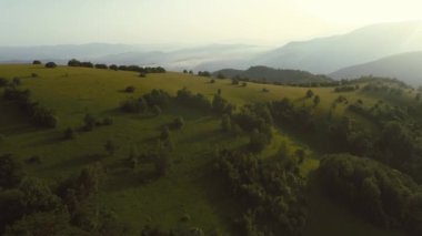 Sonsuz bir dağ ve orman manzarasının sinematik görüntüsü. Gün batımında Dağ 'daki tepelerin üzerinden uçacağız. Merhaba kaliteli 4K görüntüler.