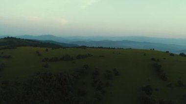 Sonsuz bir dağ ve orman manzarasının sinematik görüntüsü. Gün batımında Dağ 'daki tepelerin üzerinden uçacağız. Merhaba kaliteli 4K görüntüler.